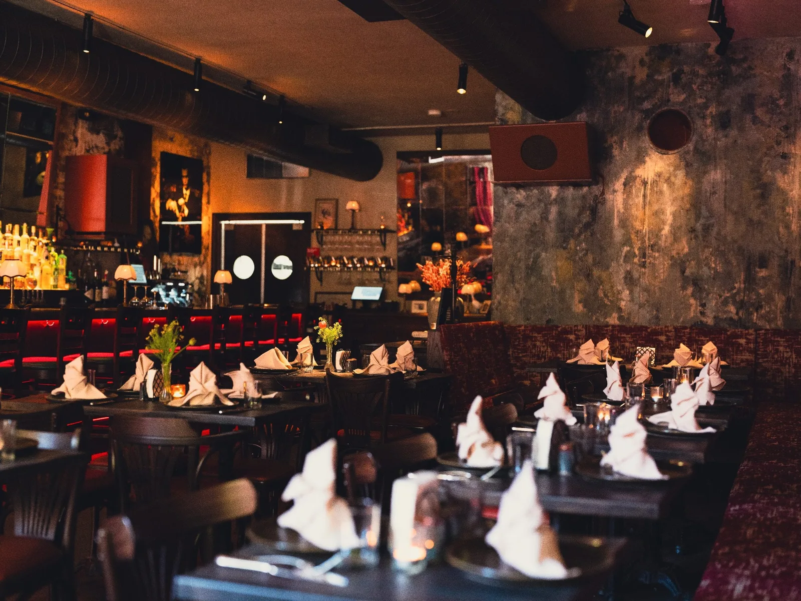 Long view down GUSI's first-floor bar in Greenwich Village — wood counter and warm tavern lighting